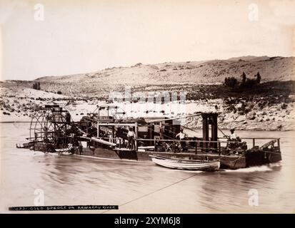 Dans les années 1880, les hommes exploitent une drague aurifère sur la rivière Kawarau près de Queenstown, en Nouvelle-Zélande, par les Burton Brothers. Banque D'Images