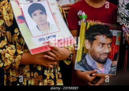 Dhaka, Bangladesh. 30 août 2024. Les gens tiennent des photos de membres de la famille disparus, lors d'un événement organisé pour marquer la Journée internationale des victimes de disparitions forcées, au centre de Shaheed Minar à Dhaka, Bangladesh, le 30 août 2024. Les gens se sont rassemblés pour un rassemblement exigeant le retour de leurs proches. Le rassemblement était organisé par Mayeer Daak, une plateforme pour les familles des victimes de disparitions forcées. Photo de Suvra Kanti Das/ABACAPRESS. COM Credit : Abaca Press/Alamy Live News Banque D'Images