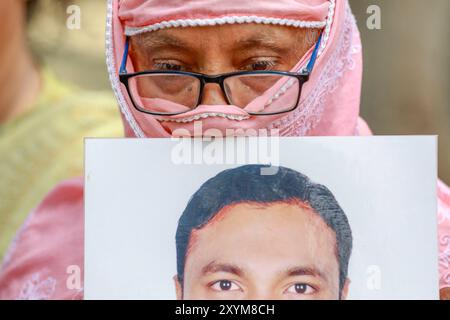 Dhaka, Bangladesh. 30 août 2024. Les gens tiennent des photos de membres de la famille disparus, lors d'un événement organisé pour marquer la Journée internationale des victimes de disparitions forcées, au centre de Shaheed Minar à Dhaka, Bangladesh, le 30 août 2024. Les gens se sont rassemblés pour un rassemblement exigeant le retour de leurs proches. Le rassemblement était organisé par Mayeer Daak, une plateforme pour les familles des victimes de disparitions forcées. Photo de Suvra Kanti Das/ABACAPRESS. COM Credit : Abaca Press/Alamy Live News Banque D'Images
