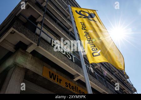 Munich, Allemagne. 29 août 2024. Le lettrage « Deutsche Post » et le logo sont visibles sur un drapeau à la succursale Deutsche Post Brief München de Munich (Bavière). Deutsche Post AG, basée à Bonn, est une société de logistique et postale cotée en bourse qui opère sous le nom de DHL Group depuis le 1er juillet 2023. Crédit : Matthias Balk/dpa/Alamy Live News Banque D'Images