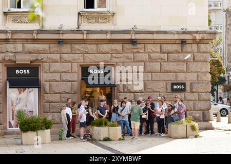 Groupe de touristes en dehors de la boutique de mode de luxe Hugo Boss à Sofia, Bulgarie, Europe de l'est, Balkans, UE Banque D'Images