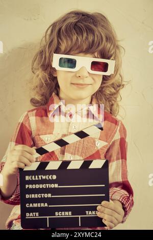 Kid holding clapper board dans les mains. Cinema concept. Retro style Banque D'Images