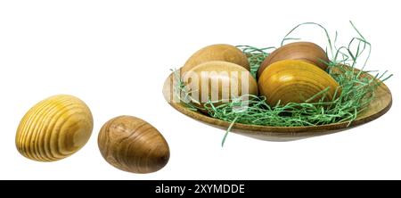 Oeufs en bois tournés à la main dans un petit bol en bois peint sur blanc Banque D'Images