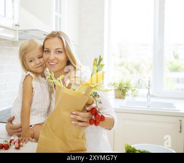 Jeune femme heureuse avec sa fille dans la cuisine une cuisine moderne mise Banque D'Images