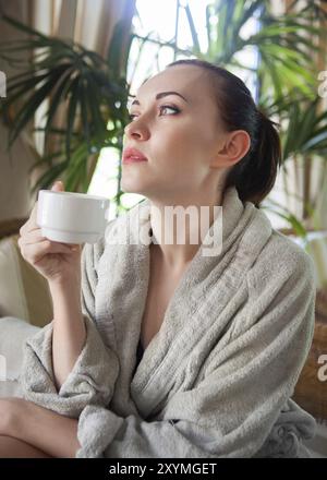 Jeune femme à boire le thé à l'ambiance détendue spa resort Banque D'Images