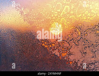 Nature fond avec motif de glace, plein soleil et gouttes d'eau sur la vitre d'hiver Banque D'Images