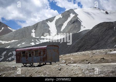 Remorque abandonnée cassée sur route de montagne. Tien Shan, Kirghizistan, Asie Banque D'Images