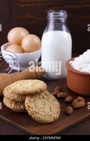 Les cookies d'avoine fait maison et les ingrédients pour la cuisson sur planche de bois rustique Banque D'Images