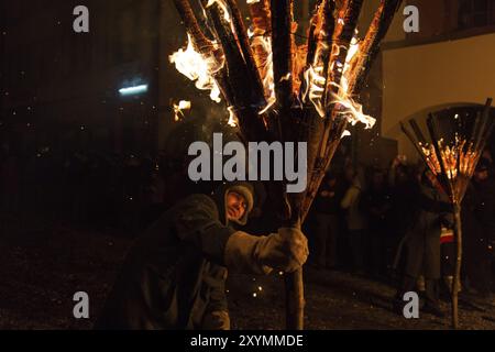 Liestal, Suisse, 09 mars 2014 : Photgraph d'un homme tenant un bâton de balai brûlant lors de la traditionnelle parade de feu Chienbaese pour Fasnacht près de Banque D'Images