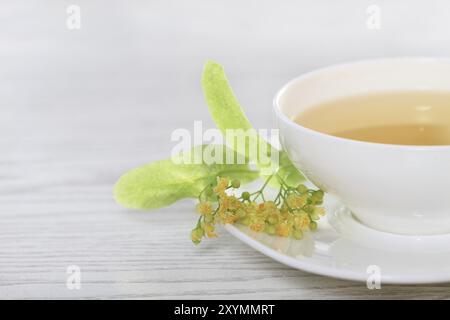 La tasse de thé de tilleul blanc sur fond de bois Banque D'Images