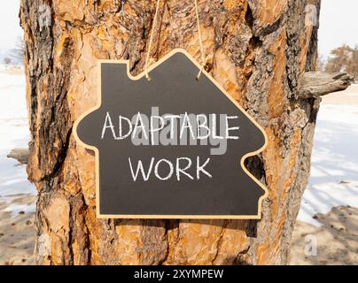 Symbole de travail adaptable. Mots-concepts adaptables sur un beau tableau noir jaune. Beau fond de vieux arbres. Concept de travail adaptable aux entreprises. Co Banque D'Images
