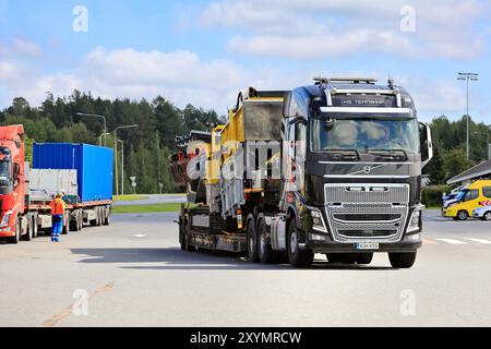 Black Volvo FH16 Truck remorque à chargement bas commence le transport de charge surdimensionné d'un crible mobile Keestrack C6. Forssa, Finlande. 8 août 2024. Banque D'Images
