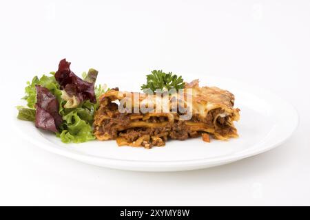 Morceau de lasagne al forno avec un peu de salade Banque D'Images