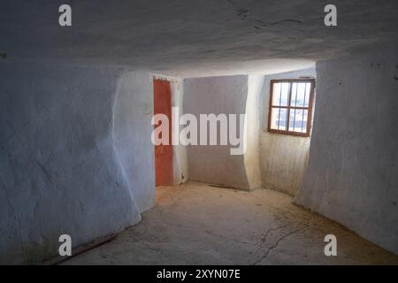 Argueda grottes abandonnées salon intérieur avec murs blancs et fenêtre, en Espagne Banque D'Images