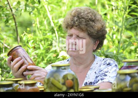 Femme au foyer mature avec une nourriture en conserve pour l'hiver Banque D'Images