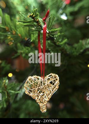 Ornement coeur doré accroché sur un arbre de Noël Banque D'Images