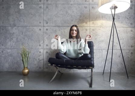 Portrait of attractive brunette woman in green sweater assis sur fauteuil essayer de se détendre Banque D'Images