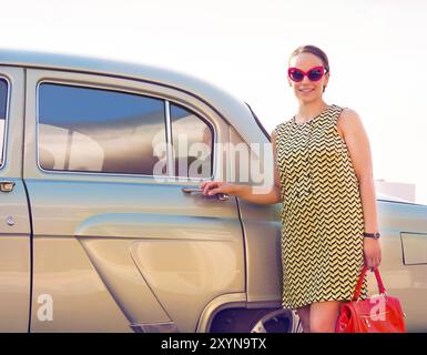 Belle brunette woman standing près de voiture rétro Banque D'Images