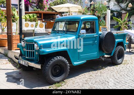 Kalkan, Turquie - 15 août 2024 : Blue Pick-up se trouve parket dans la rue par une journée ensoleillée. Willys Jeep Truck est un camion fabriqué par Willys-Overland Motors Banque D'Images