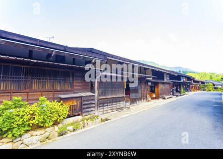 Une rangée de maisons traditionnelles japonaises en bois connecté sur la route principale dans la région de Tsumago, une station village sur la route Nakasendo historique au Japon Banque D'Images