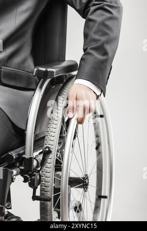 Carrière d'affaires et concept de succès de concurrence professionnelle, homme d'affaires invalide ou handicapé en costume noir assis fauteuil roulant blanc isolé Banque D'Images