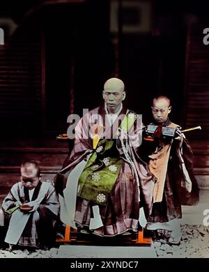 Prêtre bouddhiste avec deux acolytes - prêtre bouddhiste et deux garçons à un temple1895 par Seibei Kajima, actif dans l'ère Meiji (1868-1912). « Photographe millionnaire », qui a beaucoup contribué au monde de la photographie au Japon. Photo japonaise en noir et blanc colorée à la main Japon fin 19ème - début du XXe siècle photographie d'albumen vintage ( histoire historique ) reproduction numérique améliorée . Banque D'Images