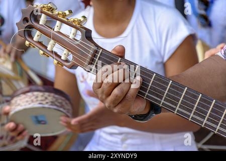 Détail de mains du guitariste et sa guitare acoustique à une piscine Présentation samba Banque D'Images