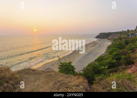 Vue en angle élevé de la plage et de l'océan pendant le coucher du soleil du soir comme le soleil approche de l'horizon dans la ville touristique falaise Varkala, Kerala, Inde. Horizontal Banque D'Images