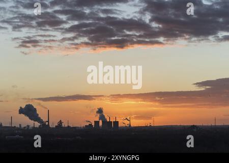 Coucher de soleil au Sechs-Seen-Platte à Duisbourg avec vue sur les cheminées fumantes à l'horizon Banque D'Images