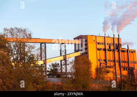 Séchage du charbon brut dans une usine. Courroies pour le transport vers la centrale thermique. La fumée pollue l'environnement. Banque D'Images