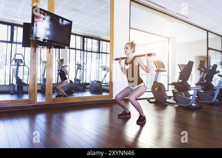 Jolie jeune femme blonde dans la salle de sport de formation Banque D'Images