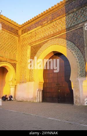 Meknès, Maroc, 4 avril 2018 : Marocains devant la porte historique de Bab El-Mansour pendant l'heure d'or en fin d'après-midi. Vertical, Afrique Banque D'Images