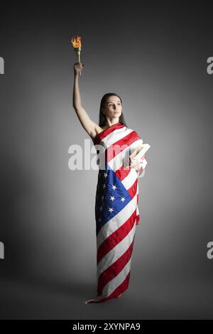 Femme dans le drapeau américain dans le style de la statue de la liberté Banque D'Images