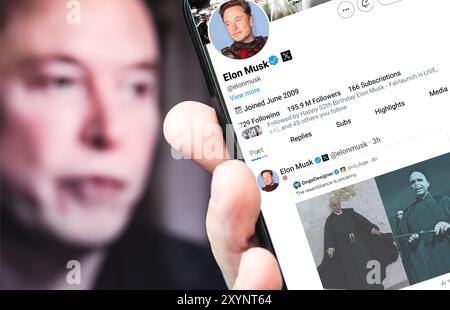 Poltava, Ukraine - 30 août 2024. Page de profil Twitter d'Elon Musk avec un smartphone à la main. En arrière-plan se trouve un portrait défocalisé d'Elon Banque D'Images