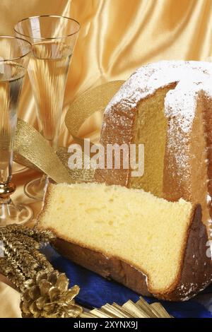 Composition de Noël avec Pandoro le gâteau doré de Vérone, deux verres de spumante et quelques ornements sur un fond jaune Banque D'Images