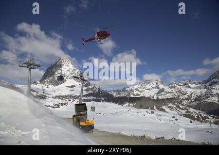 Zermatt, Suisse, 13 avril 2017 : un hélicoptère chargeant du béton sur un chantier de construction dans les montagnes suisses, en Europe Banque D'Images