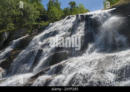 Une cascade impressionnante coule sur les rochers entourés d'arbres verdoyants par une journée ensoleillée, Cascada del Caozo, Garganta de Bonal de los Llanos, Piornal, C. Banque D'Images