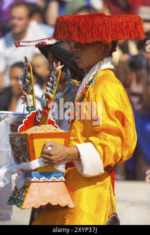 Dharamsala, Inde, 24 juin 2009 : homme tibétain portant des vêtements traditionnels colorés du Tibet, chapeau plat, tenant des cadeaux en prévision du Dalaï Lama, Asie Banque D'Images