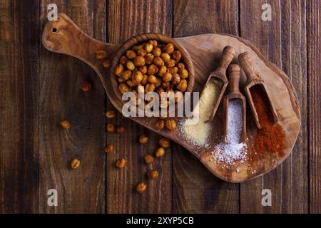 Pois chiches épicés rôtis avec sel, ail et paprika sur fond rustique Banque D'Images