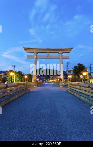 Le pont Miyamae bashi mène à la grande porte torii et à l'important sanctuaire shinto à l'heure bleue dans la destination touristique, Hida-Takayama, Japon. Vertica Banque D'Images