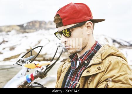 Un gars en lunettes de soleil et une casquette prépare un drone pour le vol Banque D'Images