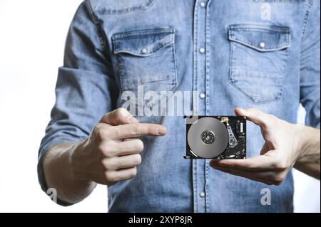 La main de l'homme tient un disque dur de 2,5 pouces. Il pointe vers le disque dur. Vue de l'arrière du disque dur, depuis la carte de circuit imprimé. Isolé sur fond blanc Banque D'Images