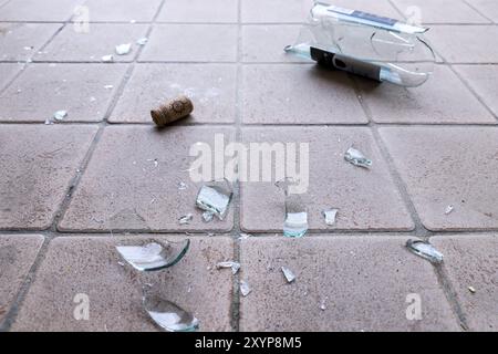 Morceau de verre brisé sur le sol, une bouteille de vin Banque D'Images