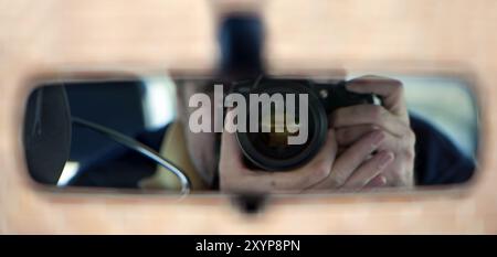 Reflet du photographe dans le rétroviseur de la voiture Banque D'Images