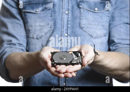 La main de l'homme tient un disque dur de 2,5 pouces. Il pointe vers le disque dur. Vue de l'arrière du disque dur, depuis la carte de circuit imprimé. Isolé sur fond blanc Banque D'Images