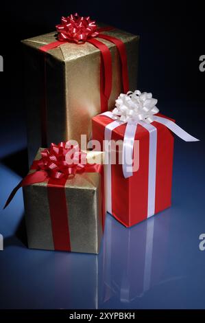 Boîtes cadeaux de Noël brillantes dans l'obscurité Banque D'Images