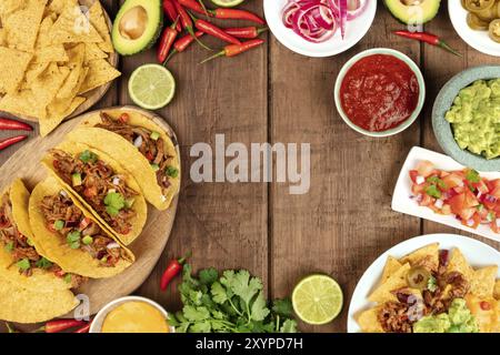 Une photo prise à la verticale d'un ssortment de beaucoup de différents aliments mexicains, y compris des tacos, guacamole, pico de gallo, nachos et autres, avec copie espace Banque D'Images