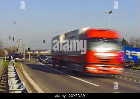 Le camion rouge traverse un carrefour à grande vitesse Banque D'Images