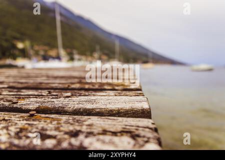 Quai rustique en bois, littoral dans un arrière-plan flou Banque D'Images