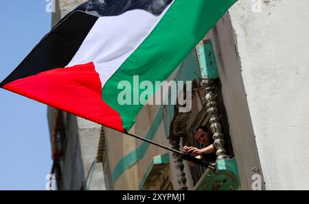 Gaza, Palestine, 29 mai 2022. Les Palestiniens brandissent leur drapeau national dans la ville de Gaza pour protester dimanche contre la marche du drapeau israélien dans la vieille ville de Jérusalem. La Marche du drapeau est un événement annuel marquant la prise de Jérusalem-est par Israël en 1967, avec des nationalistes israéliens de droite chantant et dansant pendant le rassemblement et insultant les Palestiniens. La tension déjà élevée dans la région a été aggravée par la prise d'assaut par des ultranationalistes israéliens et des colons israéliens de l'enceinte de la mosquée Al-Aqsa, avant et pendant la marche Banque D'Images